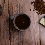 espresso in a cup next to a French press and scattered coffee beans spilling from a bag marked "espresso"