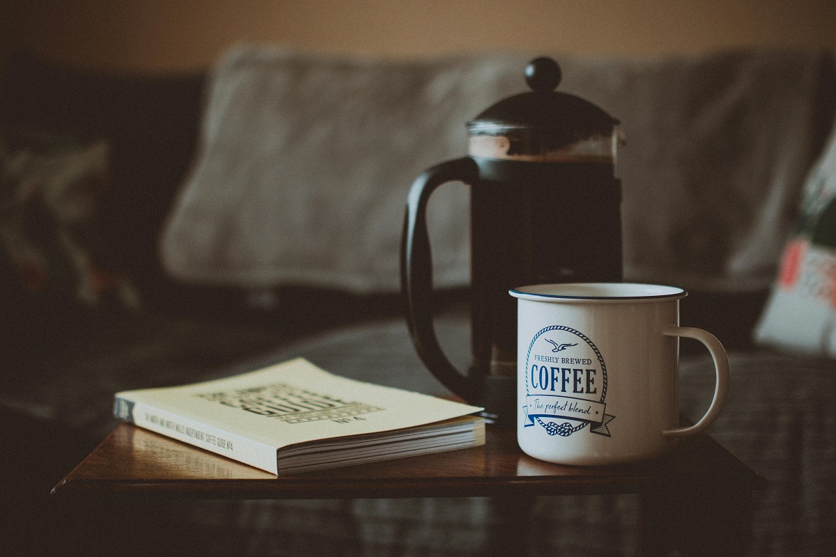 book, french press, and coffee mug on coffee table