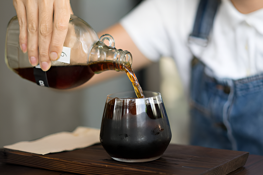 barista pouring cold brew coffee into a glass